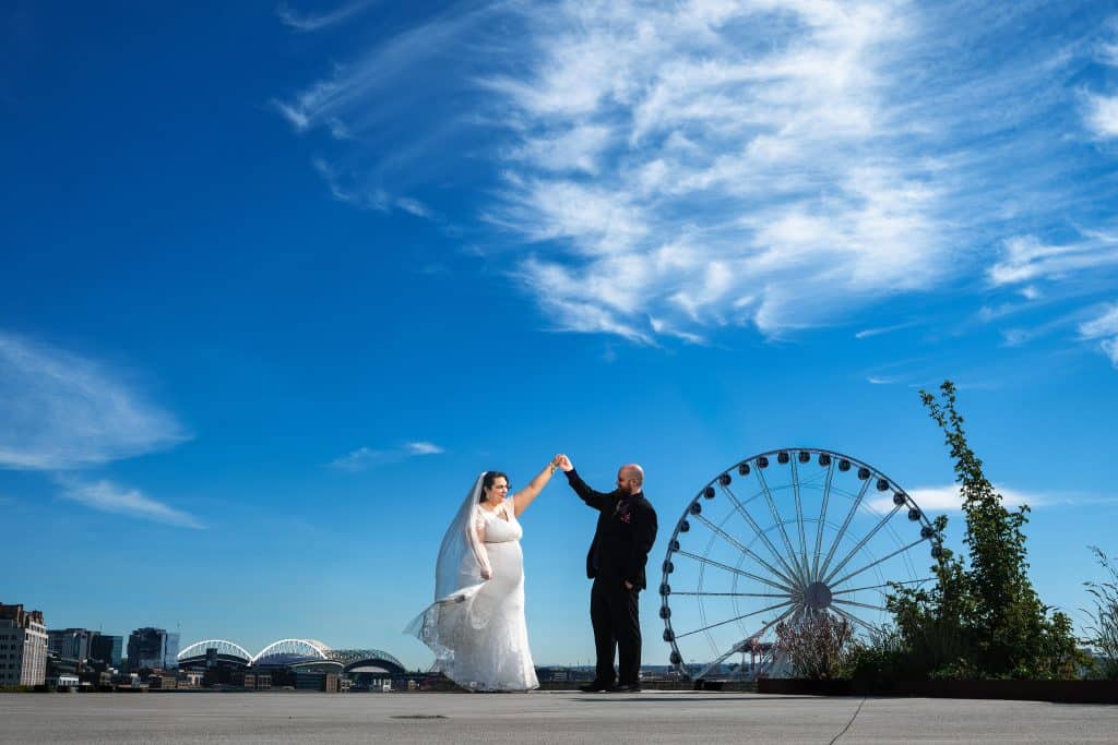 Bainbridge-Island-Wedding-Seattle-Wedding-photographer_0036 - Ann Arbor Wedding Photographer Neal spinning Kate with a ferris wheel and blue skies behind them